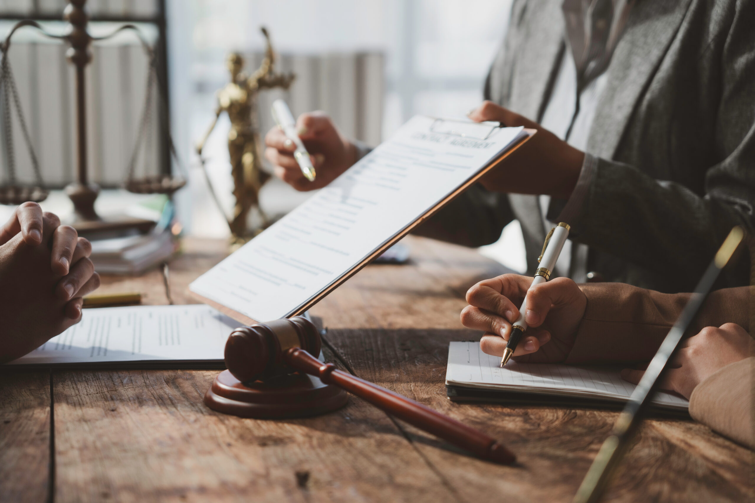 Hands reviewing a contract across a wooden desk